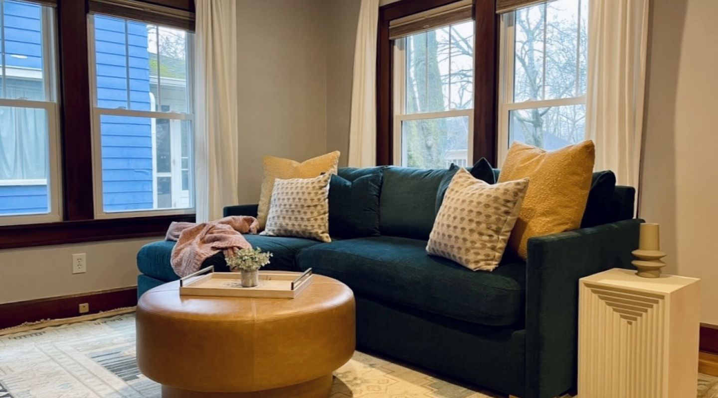A cozy living room featuring a blue couch adorned with yellow pillows, creating a vibrant and inviting atmosphere.