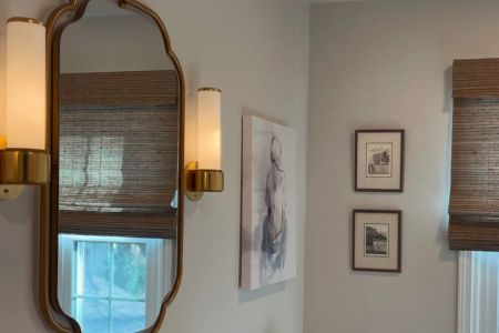 A bathroom featuring a mirror above a sink and a window allowing natural light to enter the space.