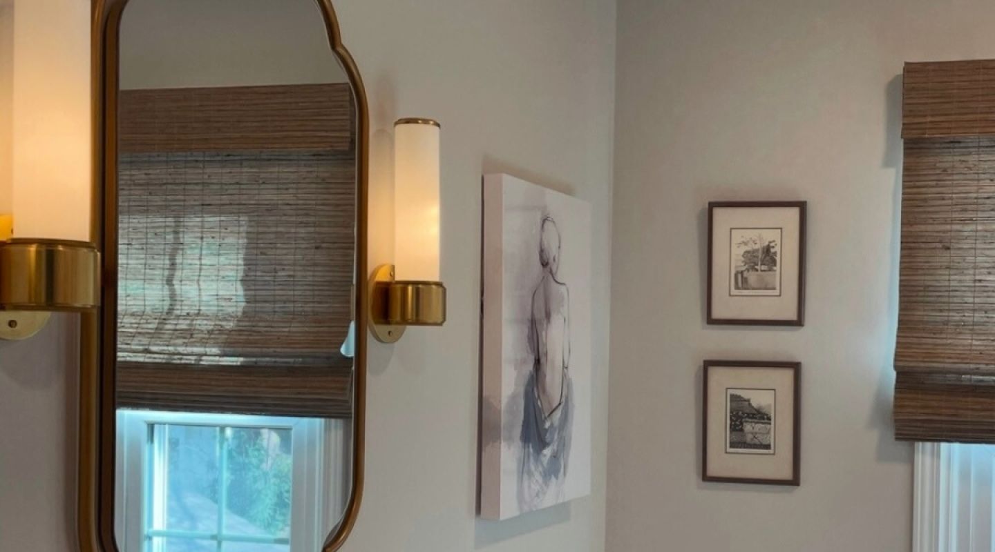 A bathroom featuring a mirror above a sink and a window allowing natural light to enter the space.