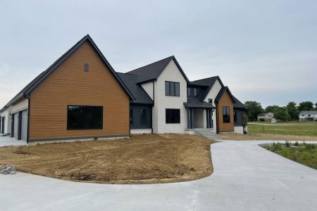 A spacious home featuring a wide driveway and an expansive garage.