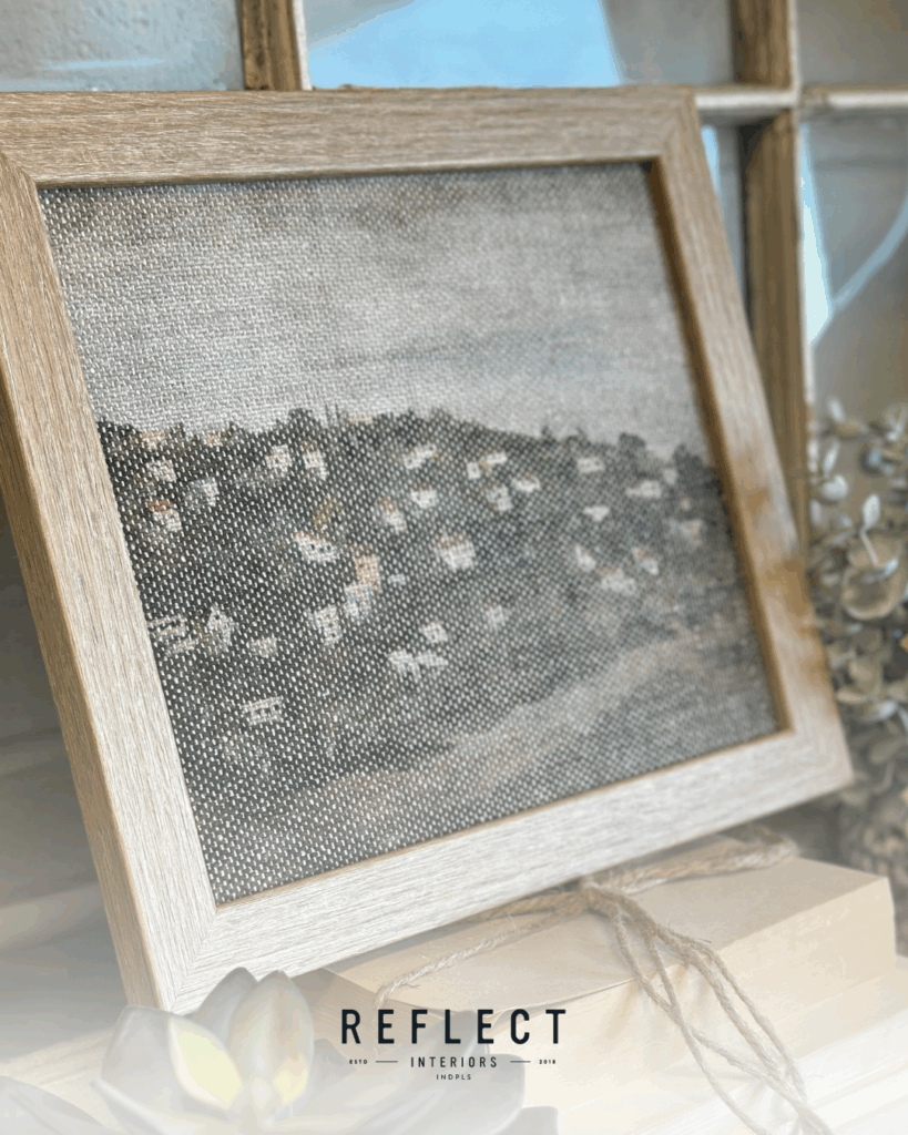 A framed painting of colorful flowers displayed on a wooden shelf.